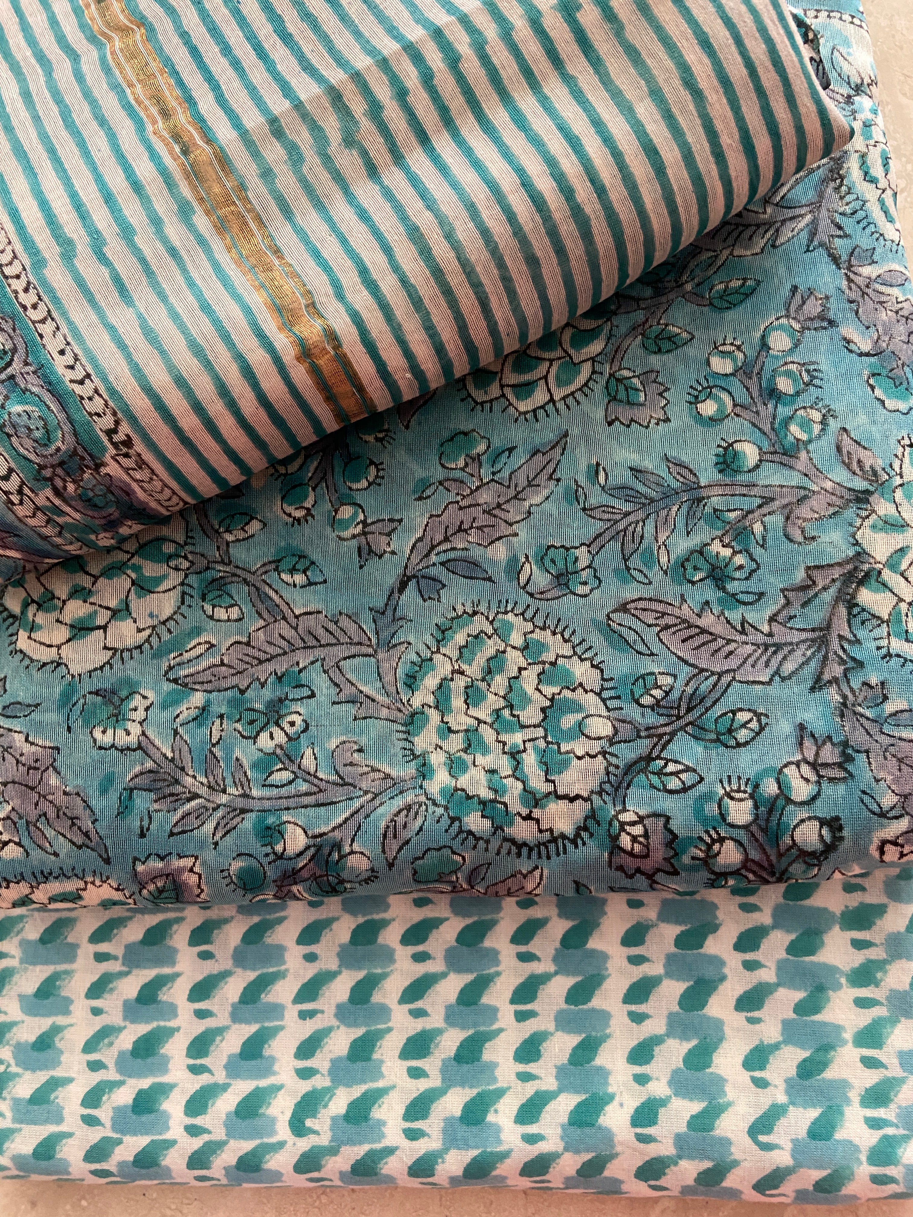 Close-up of Peacock Blue Chanderi kurta fabric showing dense padded geometric motifs in cream and gold on rich peacock blue base - traditional three-dimensional handloom weaving technique, Madhya Pradesh | Bloomton Designs